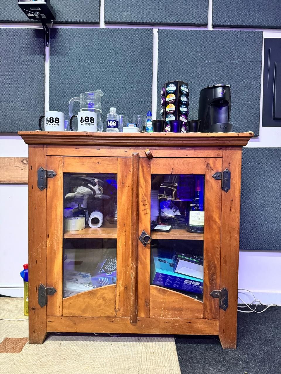 Bancada de apoio do estúdio com café, água e canecas para os convidados