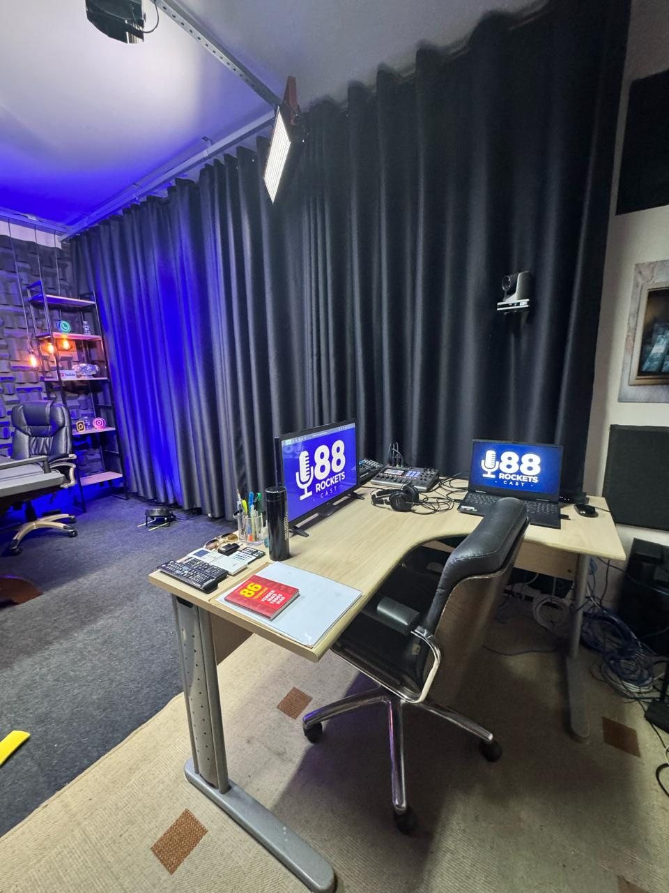 Ilha de edição do estúdio com dois monitores exibindo a marca 88 Rockets Cast