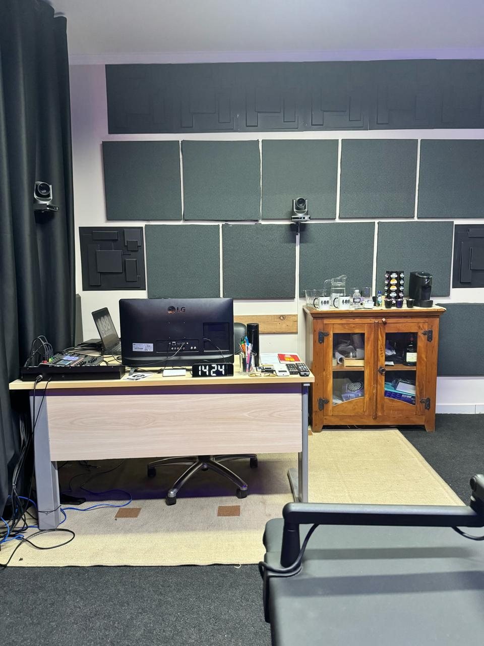 Sala de controle com monitores e mesa de áudio